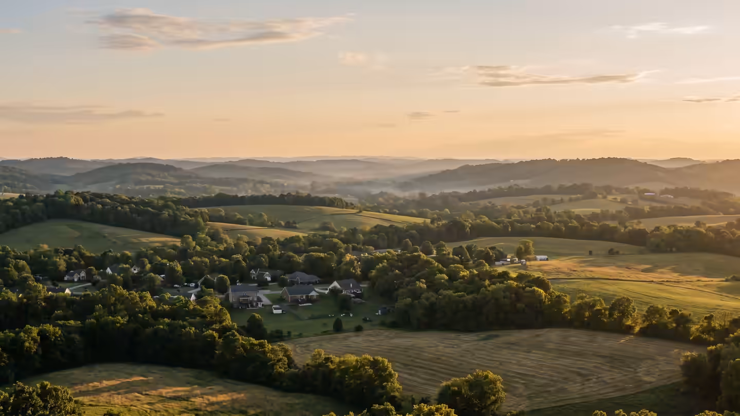 Rolling Middle Tennessee hills at golden hour, with a neighborhood tucked into the fields