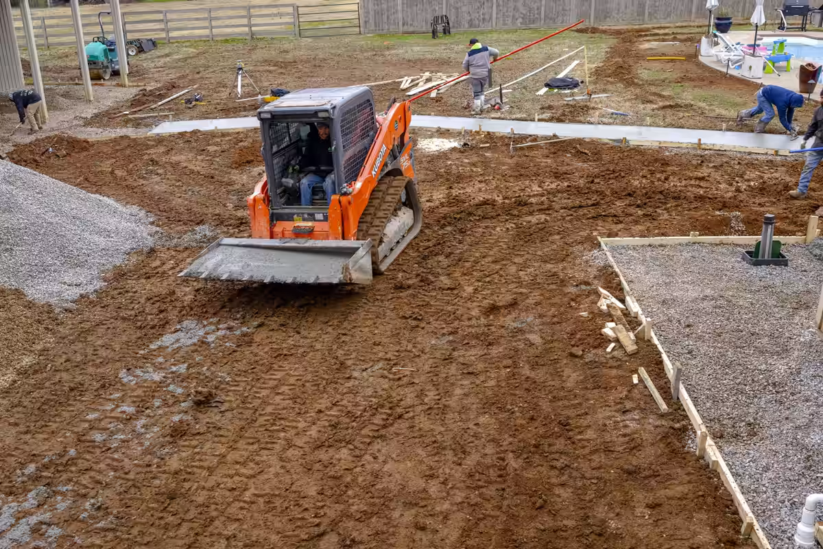 Track loader grading a backyard