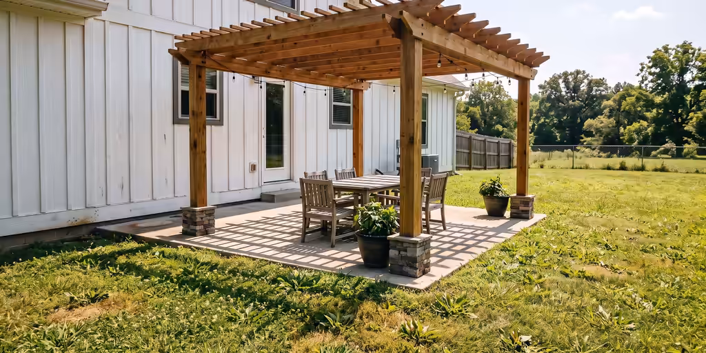 After: The same patio under a stained cedar pergola on stone-veneer bases, with a dining table, plants and string lights