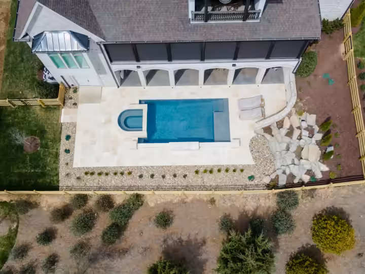 Aerial view of the finished pool, travertine terrace, boulders and planted beds