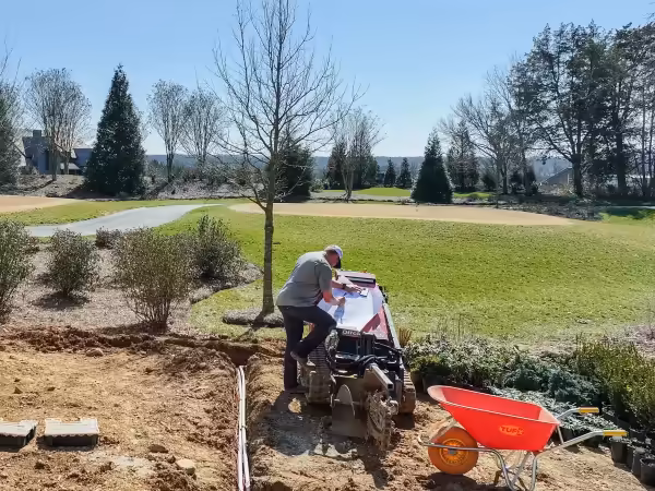 Richardson team member reviewing a plan on site with the yard behind