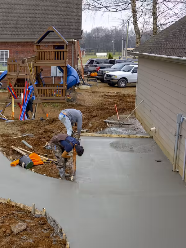 New broom-finished concrete driveway curving up to a home