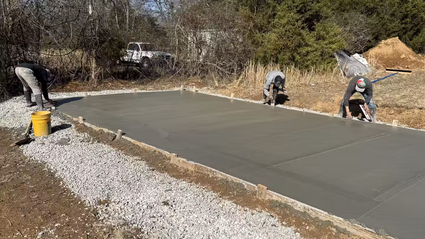 Richardson crew finishing the edges of a freshly poured concrete pad on a gravel base