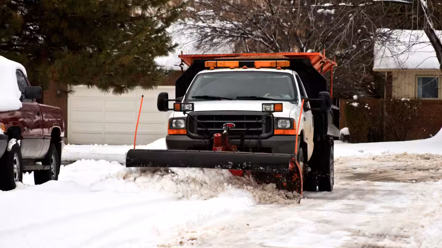 Richardson plow truck clearing snow from a drive in front of a house