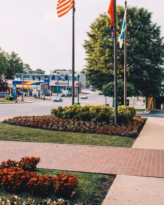 Flag poles and fresh seasonal beds along a downtown Columbia walkway