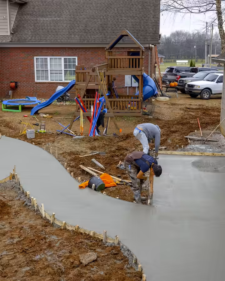 Richardson crew pouring a curving concrete walkway beside a garage